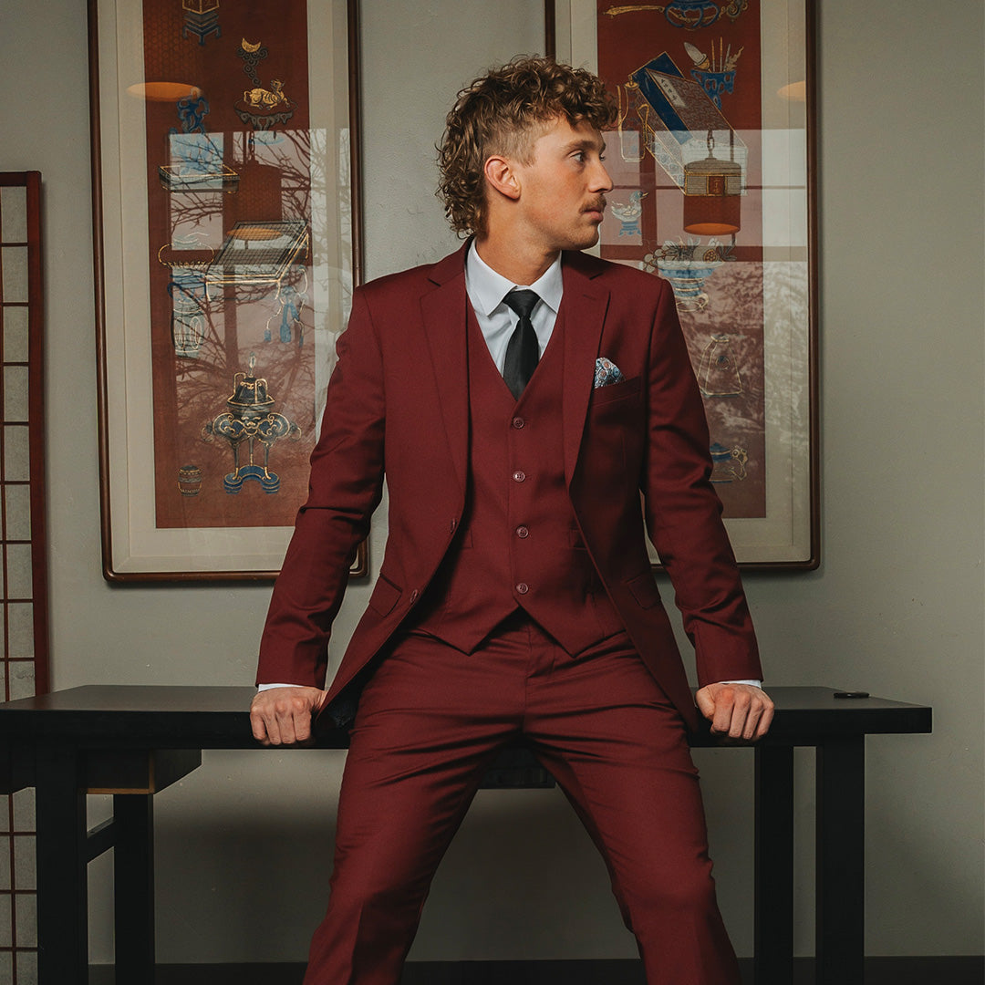 Man standing in a red suit that he got as a prom rental from Jack's Choice.