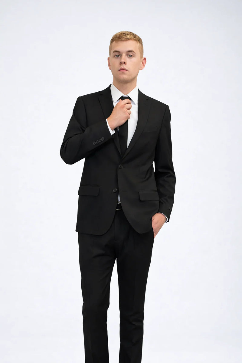 Man in Men's Black Slim Fit 2 Piece Suit with white dress shirt and black tie on plain background